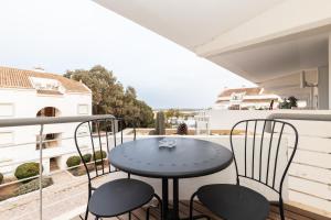 een tafel en stoelen op een balkon met uitzicht bij Cabanas Apartments Sea View in Cabanas de Tavira