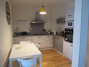 a kitchen with a table and a white table and chairs at LA MONTILLE in Le Mont-Dore