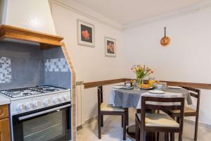 a kitchen with a stove and a table with chairs at Holiday Home Giovanni Vabriga with private Jacuzzi in Vabriga