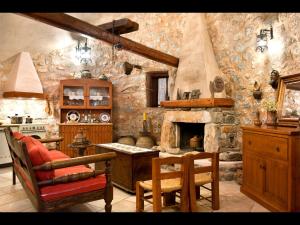 uma cozinha com uma parede de pedra e uma lareira em Arapakis Historic Castle em Pirgos Dhirou