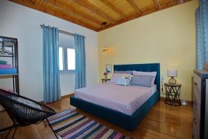 a bedroom with a bed in a room with blue curtains at Lidromi Home (Sky) in Patitiri