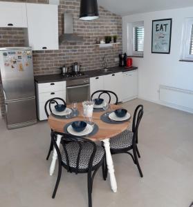 een keuken met een houten tafel met stoelen en een koelkast bij Apartment MIVA in Brela