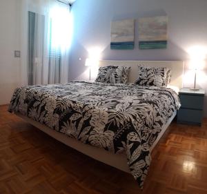 a bedroom with a black and white bed with two lamps at Apartment MIVA in Brela