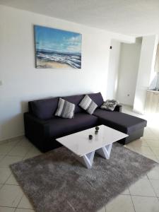 a living room with a blue couch and a white coffee table at Apartment 3 in Zadar