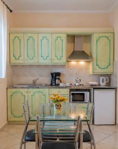 a kitchen with a glass table and chairs in it at Ziogas Luxury Apartments in Dassia