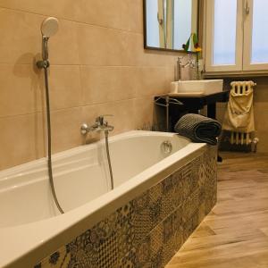 a bathroom with a bath tub and a sink at Lu.Lu Suite and Rooms in Piacenza +8 photos