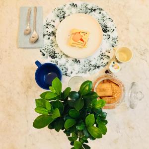 a table with a plate of food and a plant at Lu.Lu Suite and Rooms in Piacenza