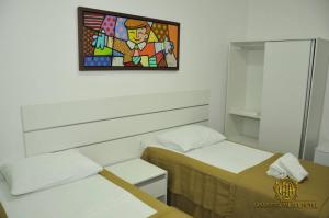 a room with two beds and a painting on the wall at Araripina Palace Hotel in Araripina