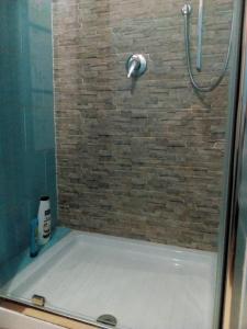 prysznic z wanną i kamienną ścianą w obiekcie casa porta nuova w mieście Palermo