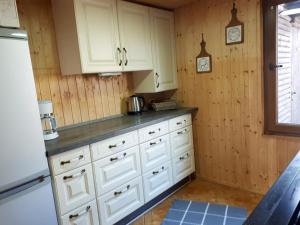 a kitchen with white cabinets and a refrigerator at Blockhütte Rudolf in Zerbst