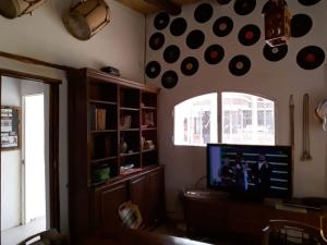 a living room with a flat screen tv and a shelf at Hostal Tierra Andina Cafayate in Cafayate