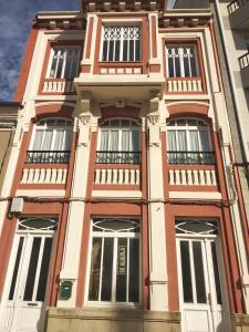 un edificio alto con ventanas y balcones. en Apartamentos San Roque en Ribadeo