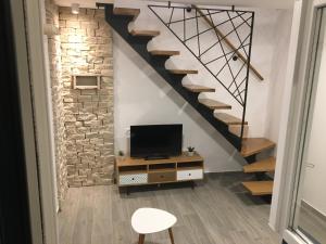 ein Wohnzimmer mit einem TV und einer Treppe in der Unterkunft Paradise Stone Apartments in Bol