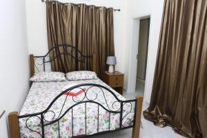 - une chambre avec un lit à baldaquin et des rideaux dans l'établissement Apartamento Júnior, à Praia