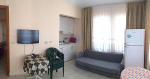 - un salon avec un canapé et un réfrigérateur dans l'établissement ÖZNUR APART OTEL, à Sidé