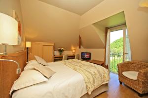 a bedroom with a large bed and a window at Hotel Beau Site - Rocamadour in Rocamadour