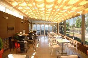a restaurant with tables and chairs and windows at Hotel Majadahonda in Majadahonda