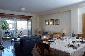 een eetkamer met een tafel en een bank bij Beach House, Labruge, Porto in Labruge