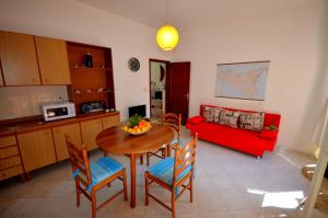 ein Wohnzimmer mit einem Tisch und einem roten Sofa in der Unterkunft Naxos Sea Holiday Apartments in Giardini-Naxos