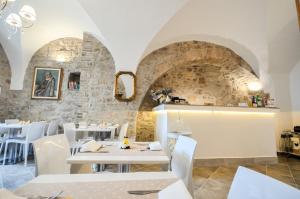 a restaurant with white tables and white chairs at Case Brizi 10 in Assisi