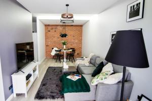 a living room with a couch and a table at Apartament MALTA COMFORT Wes Quality Suite in Poznań