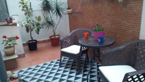 プエルト・デ・サグントにあるBonito apartamento para vacaciones en Puerto de Saguntoの植物のあるパティオ(小さなテーブル、椅子付)