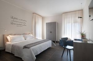 1 dormitorio con 1 cama grande y 1 silla en KissfromSalento B&B+Bike en Lecce