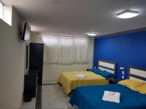 a bedroom with two beds and a blue wall at Hotel del Rosario in Zacatlán +19 photos