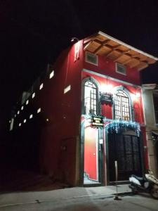 a red building with lights on it at night at Hotel del Rosario in Zacatlán