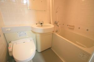 a bathroom with a toilet and a sink and a tub at るり渓フォレストコテージ in Nantan city