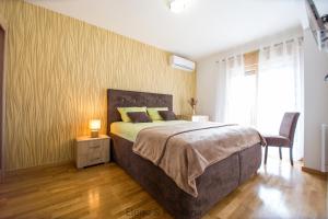 una camera con un grande letto e una sedia di Elena&Fontana Apartment a Budua