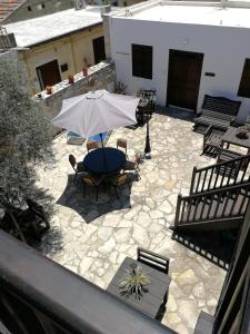 an outdoor patio with a table and an umbrella at Romios Apartments in Kalavasos