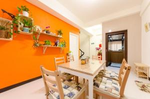 台南的住宿－拍R平方電梯民宿，一间拥有橙色墙壁和桌椅的用餐室