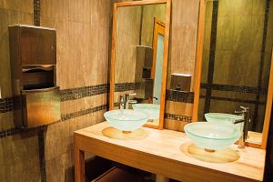 a bathroom with two sinks and two mirrors at Servotel in Port-au-Prince
