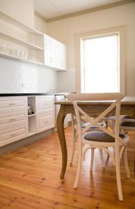 a white kitchen with a table and a chair at Cape Nelson Lighthouse in Portland