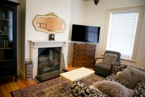 a living room with a fireplace and a mirror at Cape Nelson Lighthouse in Portland