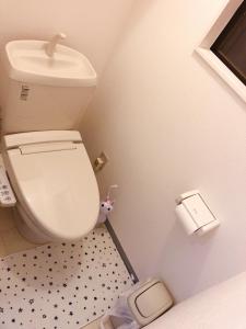 a small bathroom with a toilet and a toilet paper dispenser at C.H.House in Tokyo