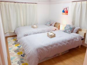 dwa łóżka w pokoju z dwoma pudłami na nich w obiekcie C.H.House w Tokio