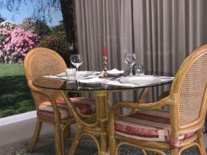 een tafel met twee stoelen en een kaars en wijnglazen bij Highgrove in Promised Land