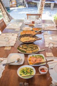 a long table with many plates of food on it at Malole Surf House in Nembrala