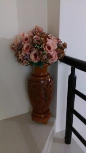 a vase filled with pink roses sitting next to a staircase at 宜蘭樸實園民宿 in Jiaoxi