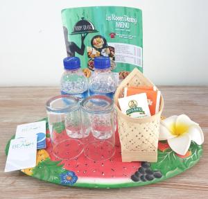 a tray with water bottles and a basket of fruit at At The Beach Candidasa in Candidasa