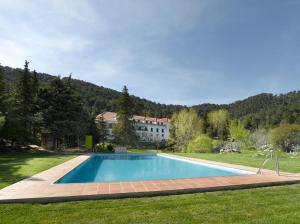 a swimming pool in a yard with a house in the background at Parador de Cazorla in Cazorla