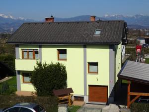 uma casa branca com um telhado castanho em Apartment Tjaša em Radovljica