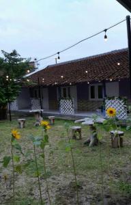 una casa con una mesa de picnic y flores en el patio en Ndalem Diajeng en Yogyakarta