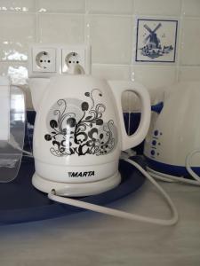 a white tea kettle with a design on it on a counter at Nevsky 126 Guest House in Saint Petersburg