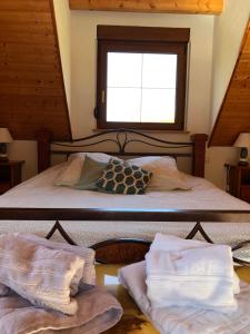 a bedroom with a bed and a window and towels at Buhl de Bonheur in Guebwiller