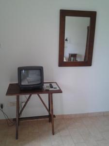 una pequeña televisión sentada en una mesa con un espejo en Agriturismo Norianino, en Montemerano