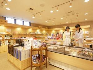 two women standing behind a counter in a store at Kyukamura Noto-Chirihama in Hakui