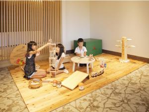 a group of three children sitting on a floor with toys at Kyukamura Noto-Chirihama in Hakui